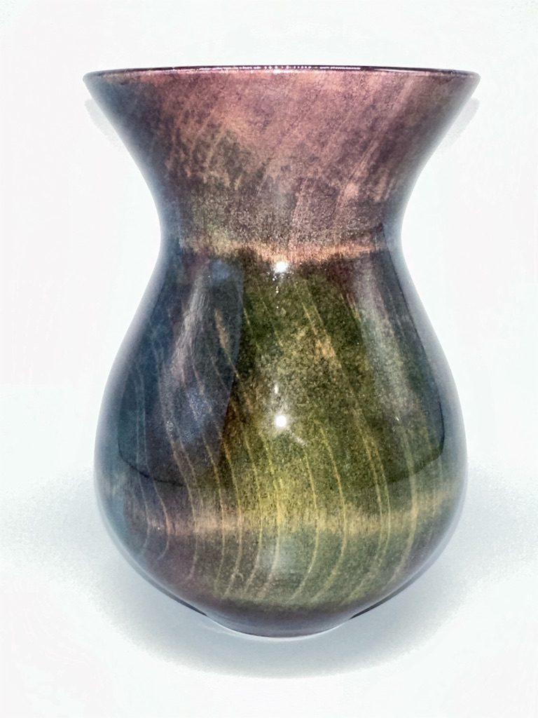 A vase with green and brown swirls on it.